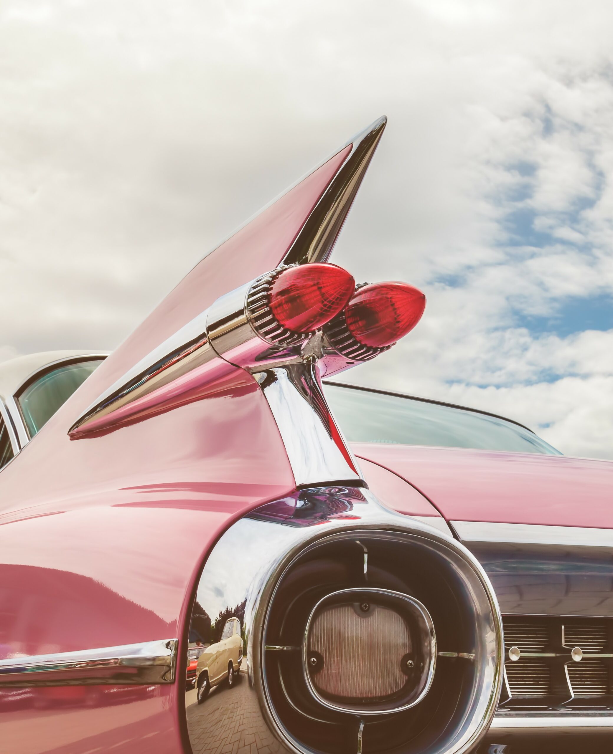 Retro styled image of the rear end of a pink classic car